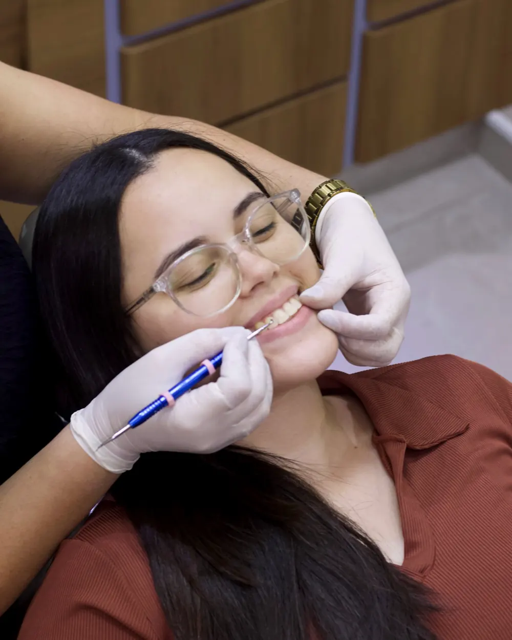Exame clínico em paciente sorridente na cadeira odontológica